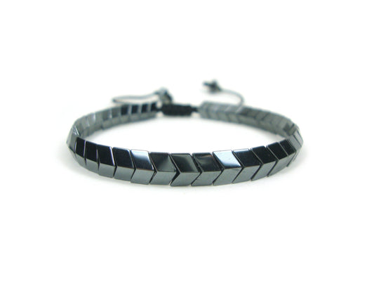 An adjustable bracelet made of natural hematite stones in an arrow shape, displayed against a white background.